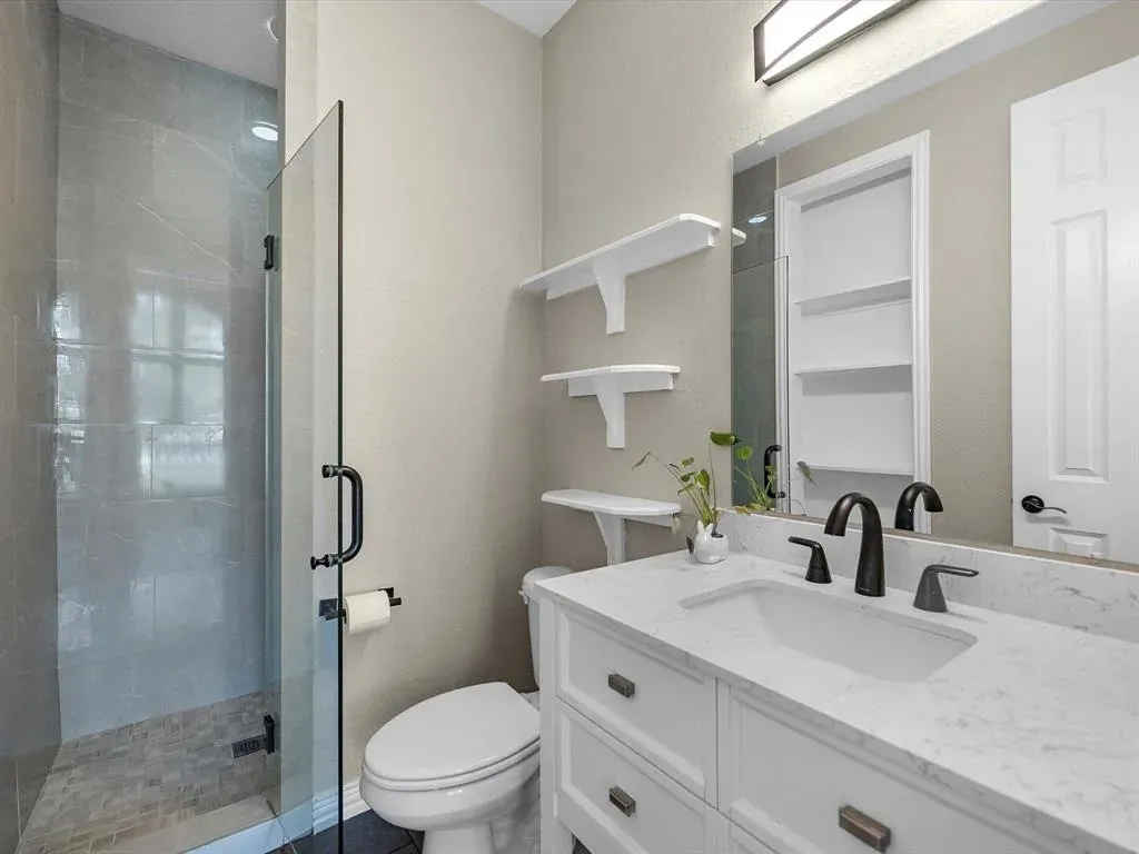 Before: Bathroom remodel in Zilker, Austin, TX with a white shaker vanity and corner shower