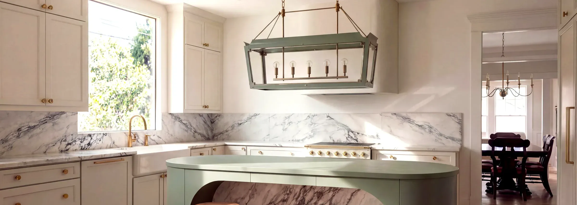 After: the remodeled kitchen with a curved sage green island and a marble backsplash