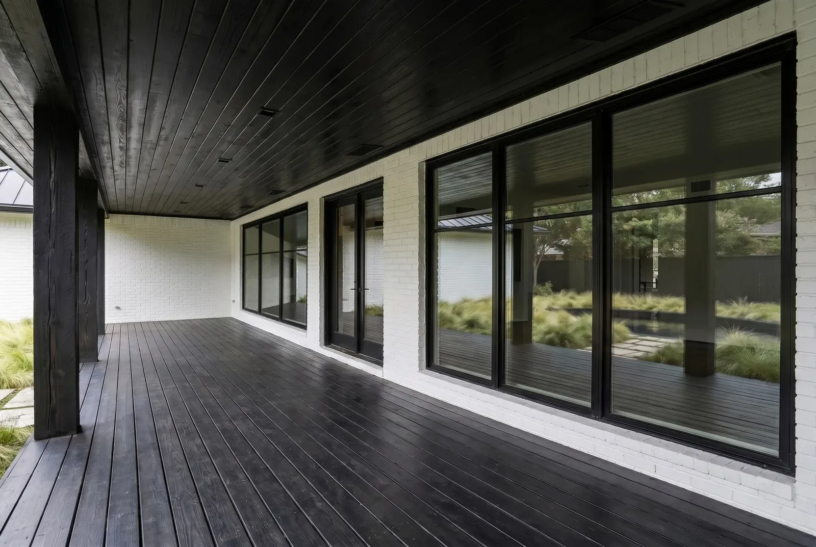 Exterior remodel in Barton Creek, Austin, TX with a blackened wood porch ceiling and deck