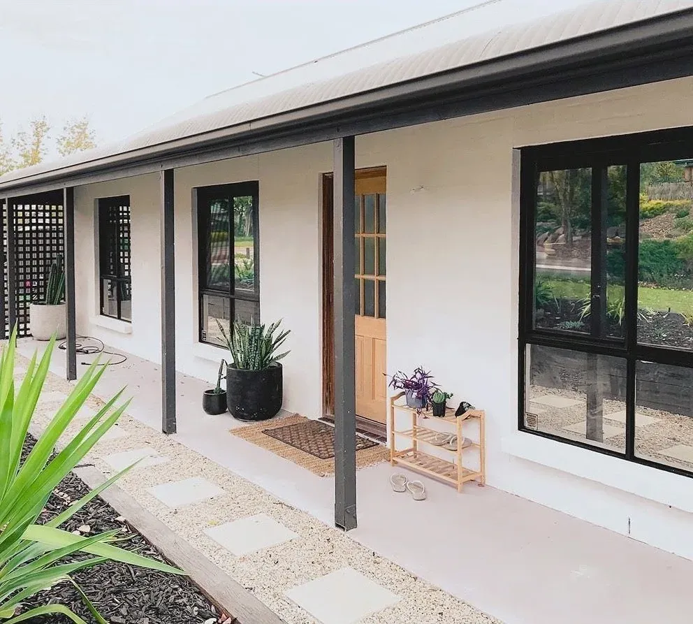 Exterior remodel in Grenada Hills, Austin, TX with white painted brick and black-framed windows