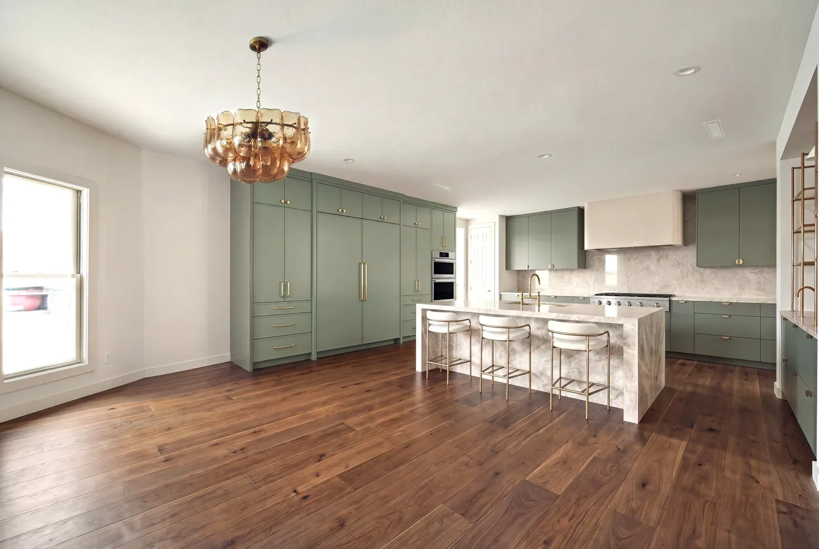 Kitchen remodel in Westlake Hills, Austin, TX with sage green cabinetry and a walnut floor