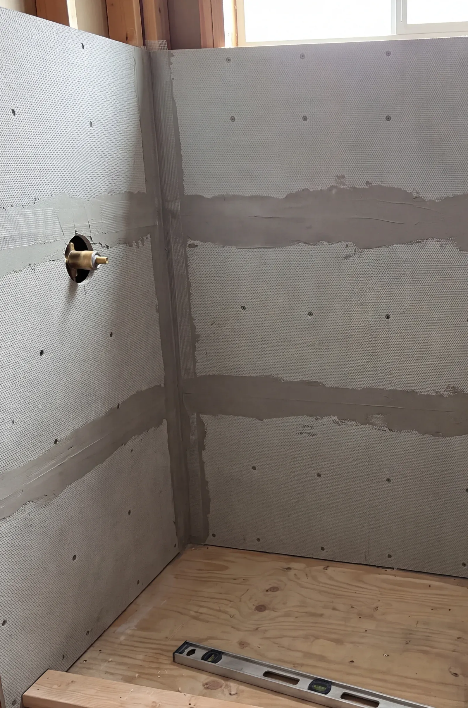 Cement board shower walls with taped and mudded seams, ready for waterproofing