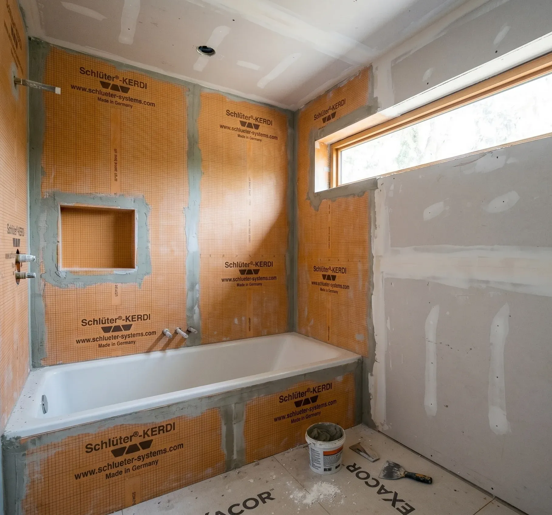 Mold-resistant construction in Austin, TX. Waterproofing membrane applied over cement board in a shower surround. Enso Homes.