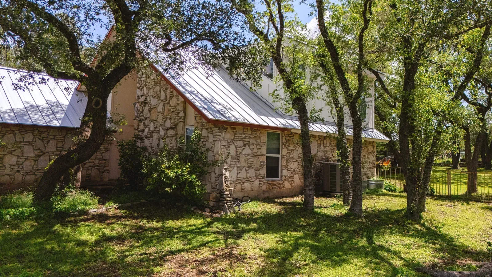 Oak Hill dormer addition with a standing-seam roof above the original stone home