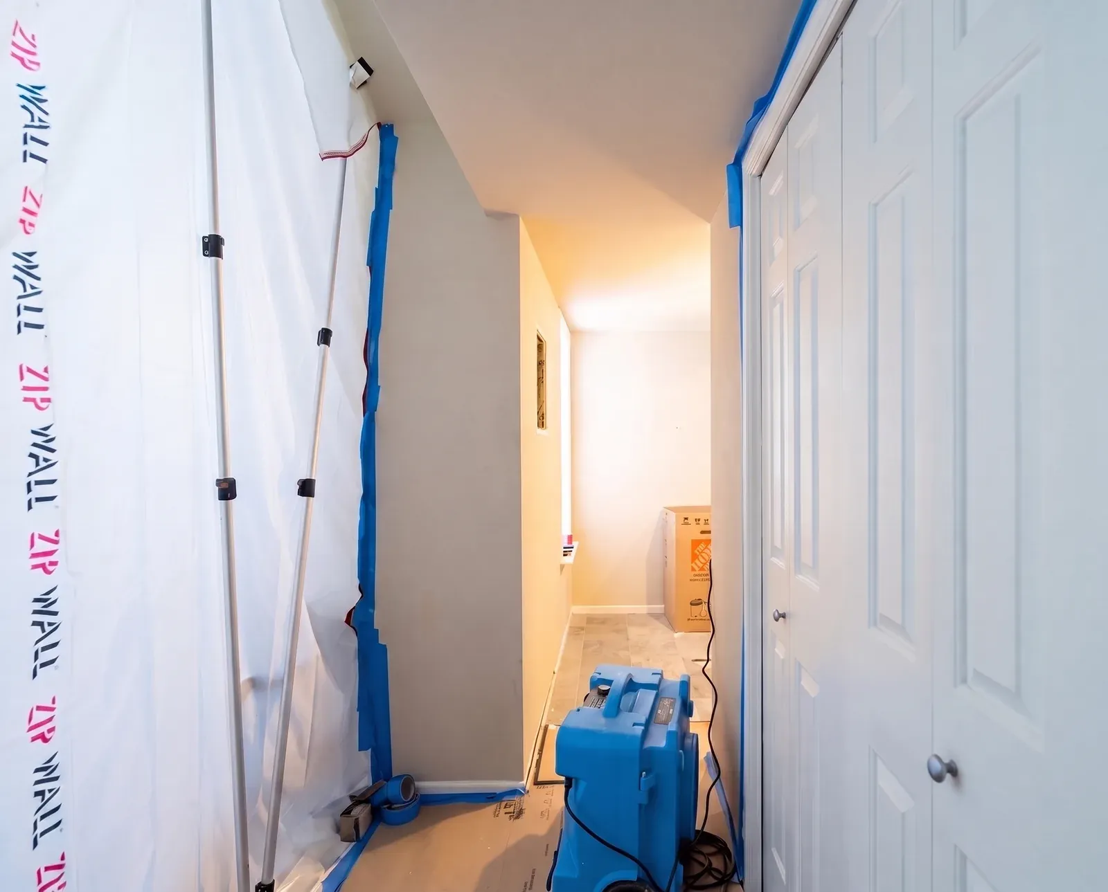 Sealed dust barrier and HEPA air scrubber set up before bathroom demo